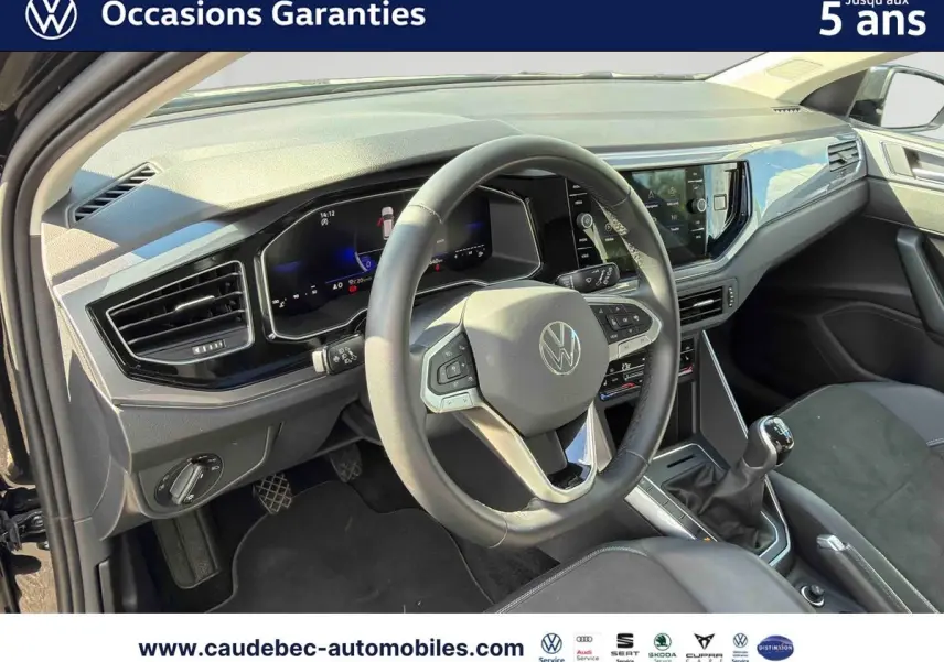 Vue intérieure de face du poste de conduite de la Volkswagen Polo 2025 avec volant cuir et boîte manuelle.