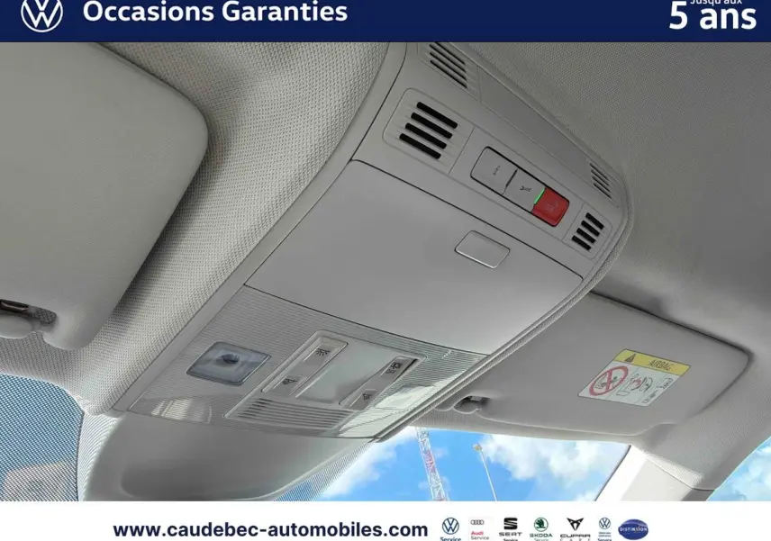 Plafonnier intérieur gris clair avec commandes d’éclairage et bouton SOS, vue depuis l’avant du Volkswagen Polo noir intense nacré.