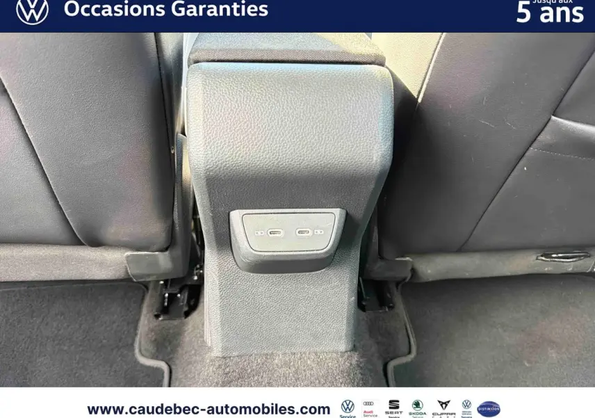 Vue rapprochée de la console centrale arrière avec deux ports USB-C entre les sièges noirs du Volkswagen Polo noir intense nacré.