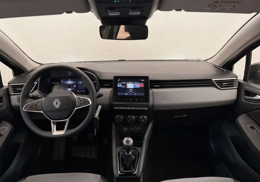 Vue frontale de l'intérieur de la Renault Clio noire 2025, avec tableau de bord moderne et écran tactile central.