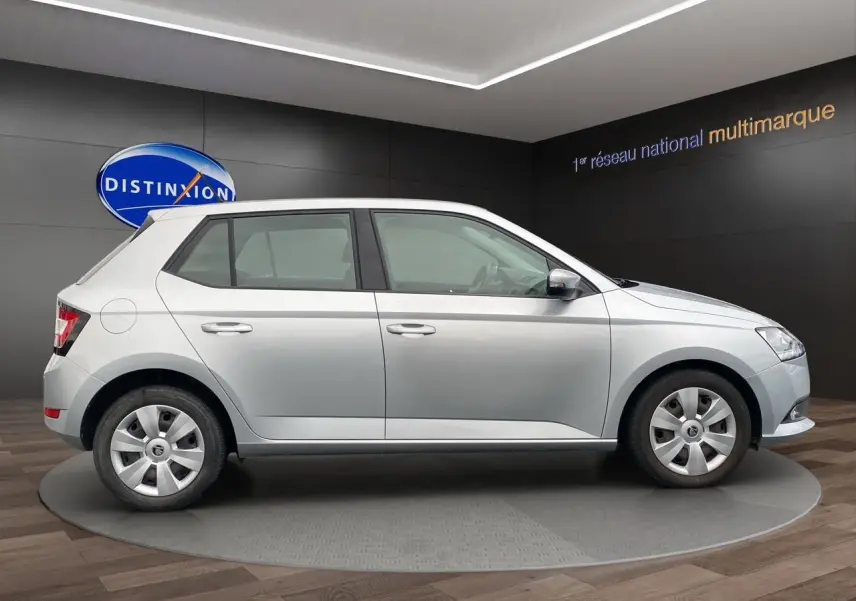 Vue de profil côté droit d'une Skoda Fabia gris argent 2021 avec jantes acier et finition Ambiente en showroom.