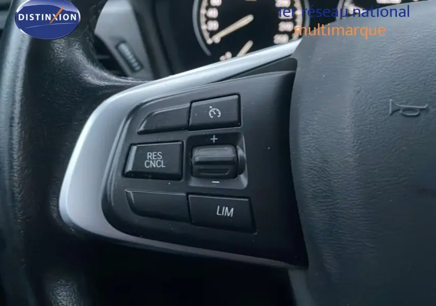 Gros plan sur les commandes de régulateur de vitesse au volant d'une BMW Série 2 Active Tourer noir saphir métal.