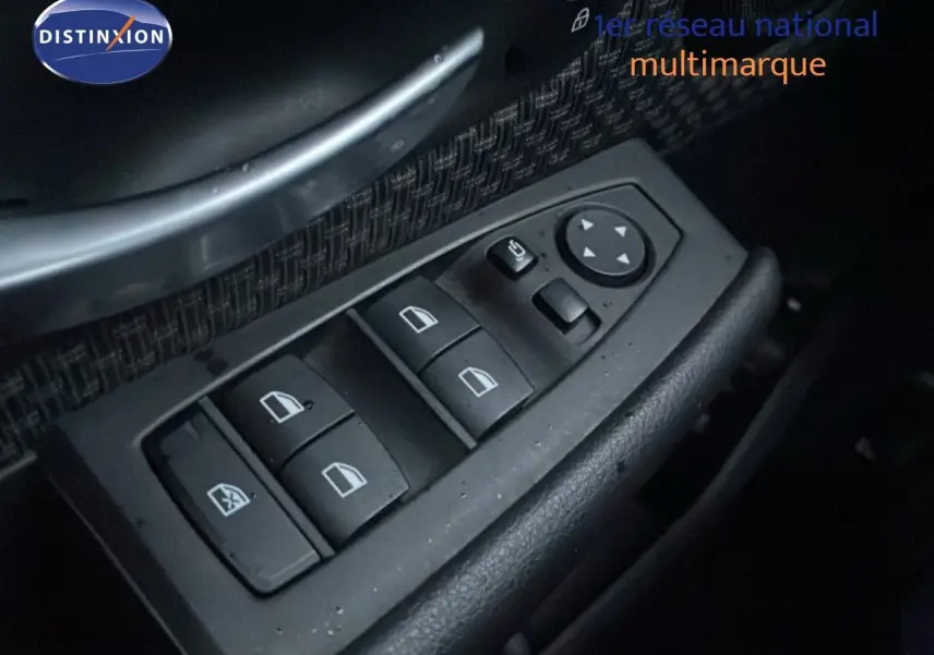 Gros plan sur les commandes des vitres électriques côté gauche d’une BMW Série 2 Active Tourer noire, intérieur tissu noir.