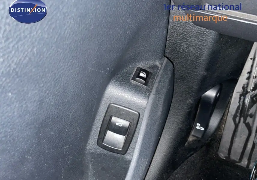 Gros plan sur les commandes d’ouverture du capot et de la trappe à carburant dans l’habitacle noir d’une BMW Série 2 Active Tourer 225XE.