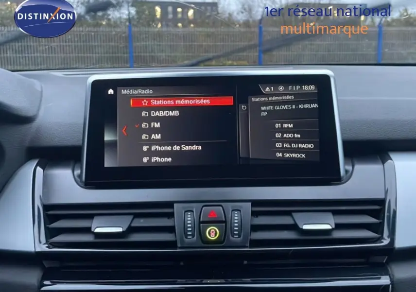 Vue intérieure centrée sur l’écran multimédia de la BMW Série 2 Active Tourer 225XE noir, affichant les stations radio mémorisées.