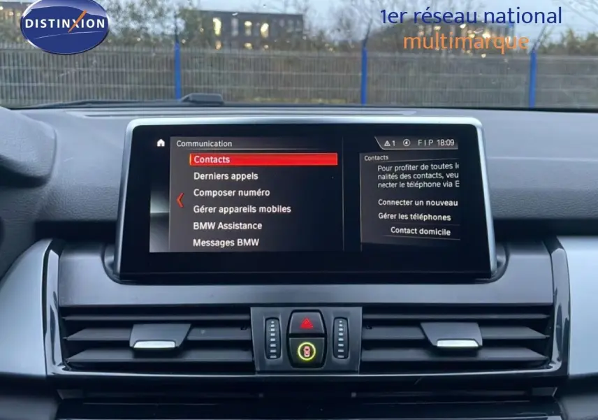 Vue intérieure du tableau de bord de la BMW Série 2 Active Tourer noire, avec écran central affichant le menu communication.