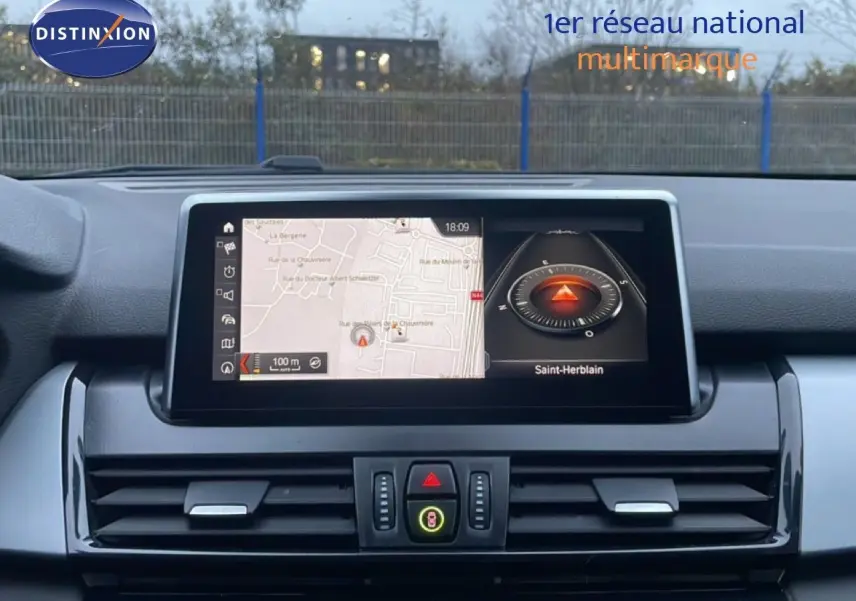 Vue intérieure centrée sur l'écran tactile du tableau de bord de la BMW Série 2 Active Tourer noir saphir, affichant la navigation.