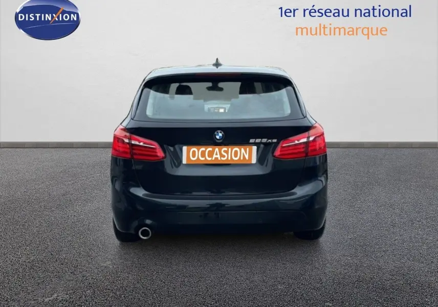 Vue arrière d'une BMW Série 2 Active Tourer noire Saphir Métal avec feux rouges et plaque "OCCASION" visible.