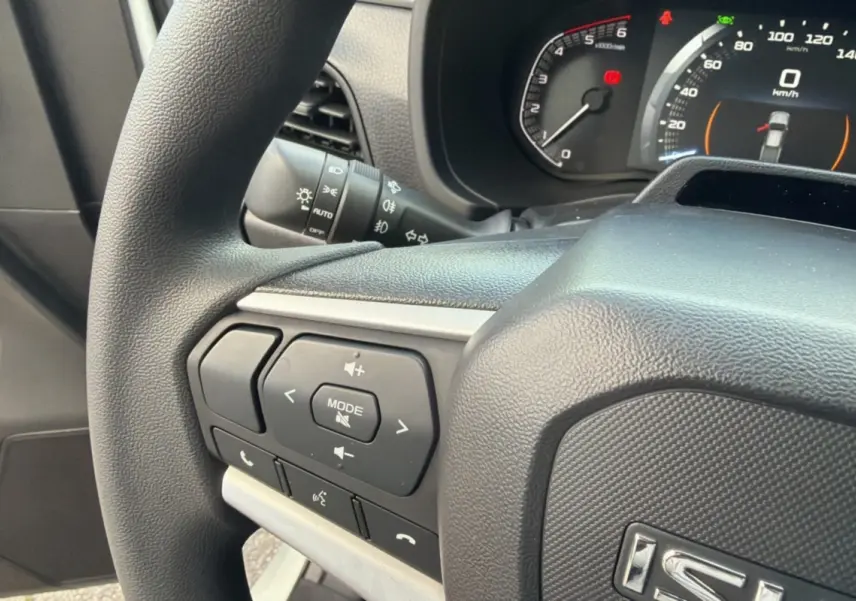 Gros plan sur le volant noir de l'Isuzu D-MAX 2026 avec commandes multifonctions et tableau de bord digital.