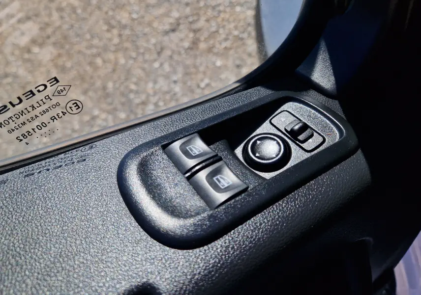 Gros plan sur les commandes électriques des vitres et rétroviseurs côté conducteur d’un Renault Master blanc 2024.