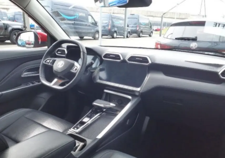 Vue intérieure avant du MG ZS 1.5 Hybrid+ 197 Luxury, tableau de bord noir avec écran tactile et volant cuir.