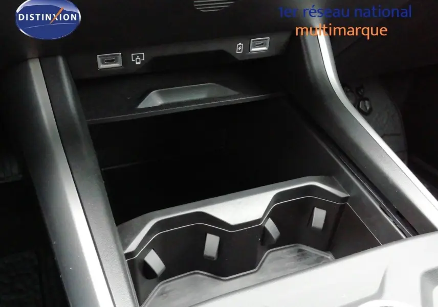 Vue rapprochée de la console centrale noire du Jeep Compass 2026, montrant les porte-gobelets et ports USB.
