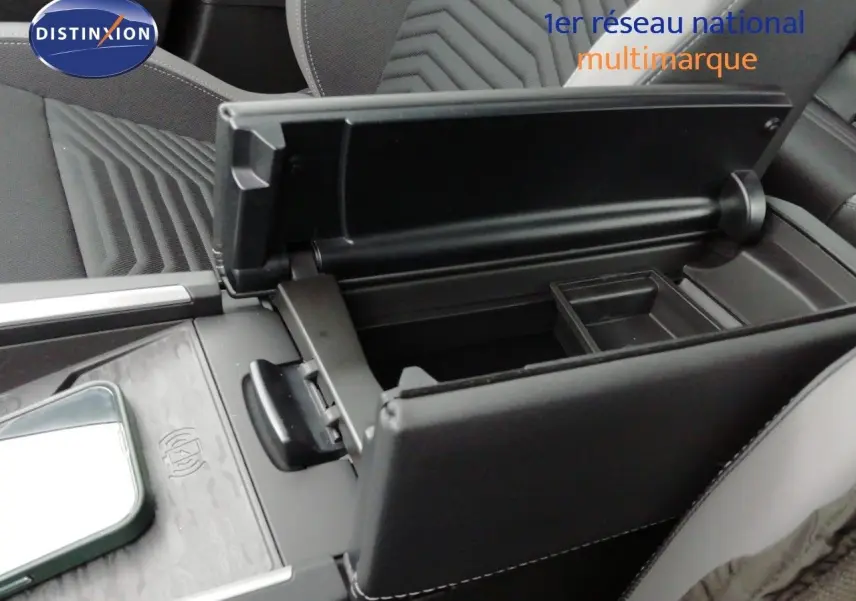 Intérieur du Jeep Compass 2026 MHEV, vue rapprochée du rangement central ouvert avec accoudoir en cuir noir.