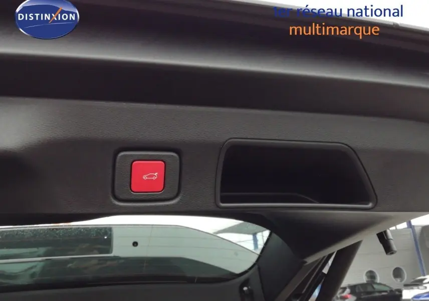 Bouton rouge d'ouverture électrique du coffre visible sur la partie intérieure du hayon d'un Jeep Compass noir Vulcano métal.