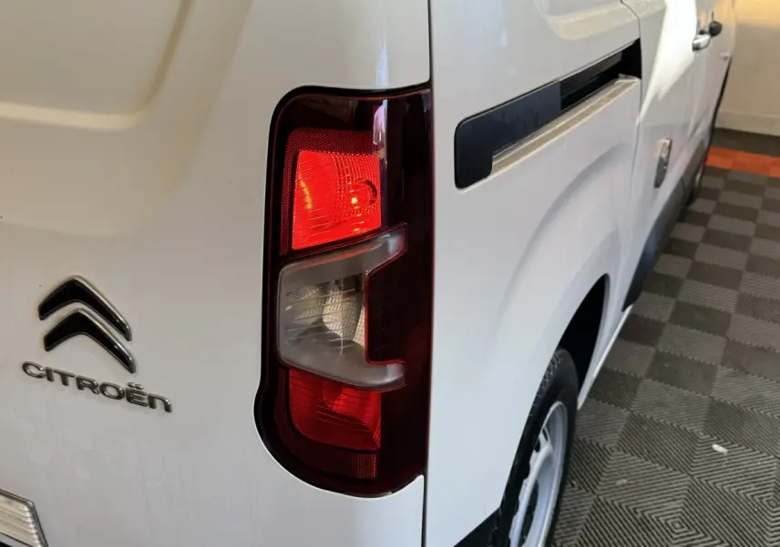Feu arrière droit allumé du Citroën Berlingo blanc, vue rapprochée du côté arrière droit du véhicule.