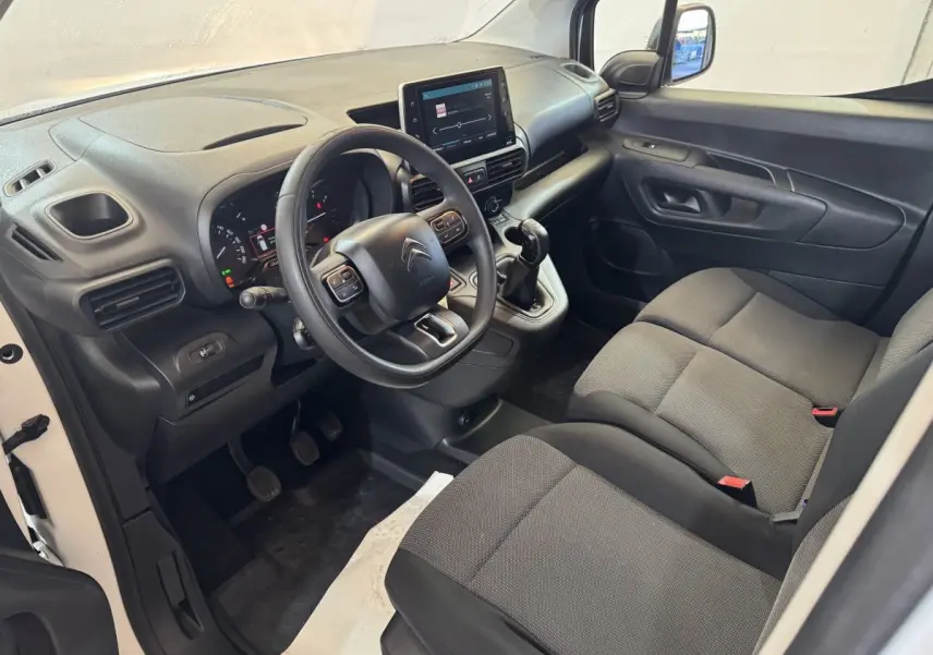 Vue intérieure côté conducteur du Citroën Berlingo blanc 2020, volant multifonctions et écran tactile central visible.