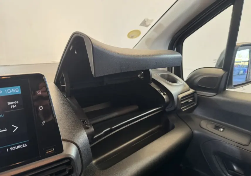 Vue intérieure côté passager du tableau de bord noir du Citroën Berlingo 2020 avec boîte à gants ouverte et écran tactile visible.