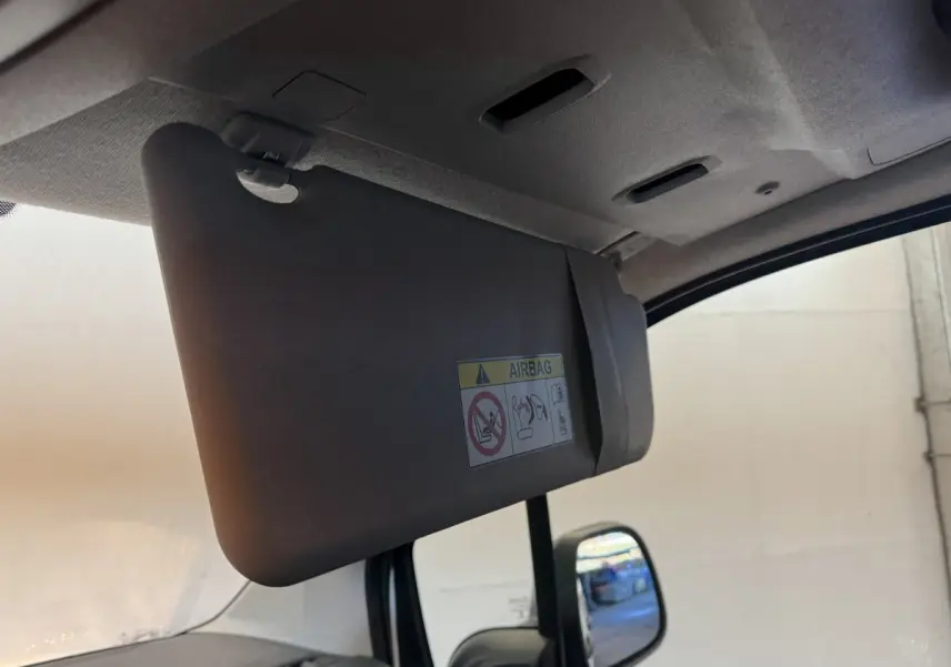 Détail du pare-soleil côté conducteur avec avertissement airbag, intérieur gris du Citroën Berlingo blanc 2020.