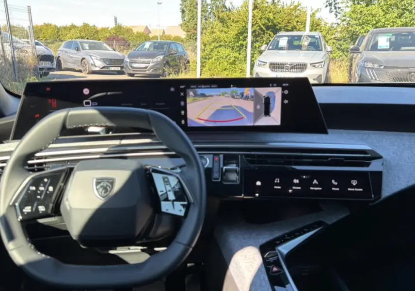 Vue intérieure du tableau de bord de la Peugeot 3008 bleu, avec volant multifonction et écran tactile affichant la caméra de recul.
