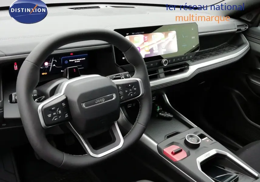 Intérieur du Jeep Compass 2026 en vue avant, volant cuir noir, tableau de bord numérique et écran tactile large.