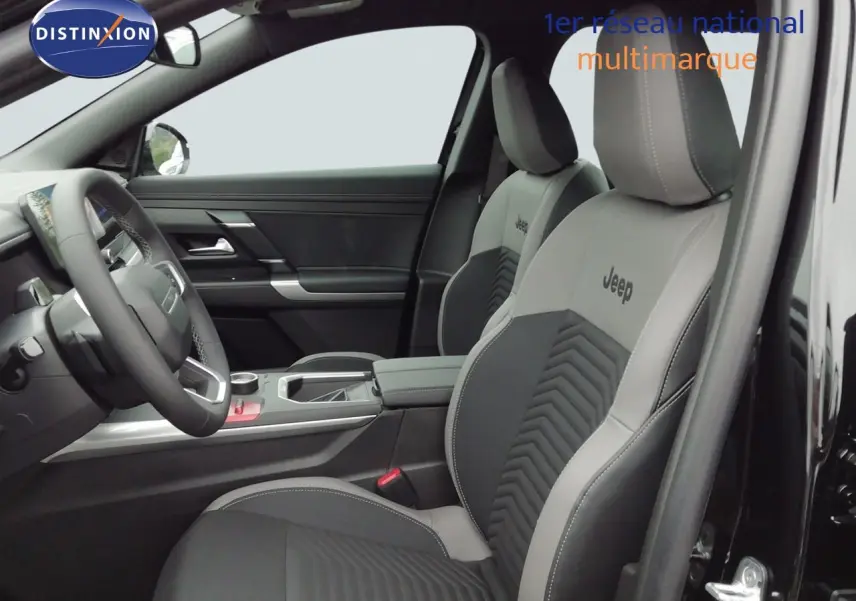 Vue intérieure côté conducteur du Jeep Compass 2026 noir Vulcano, sièges bi-ton gris et noir avec logo Jeep brodé.