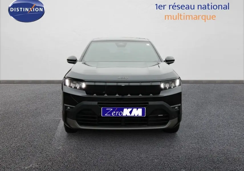 Vue frontale d'un Jeep Compass noir Vulcano métal 2026 avec calandre noire et phares allumés sur fond neutre.