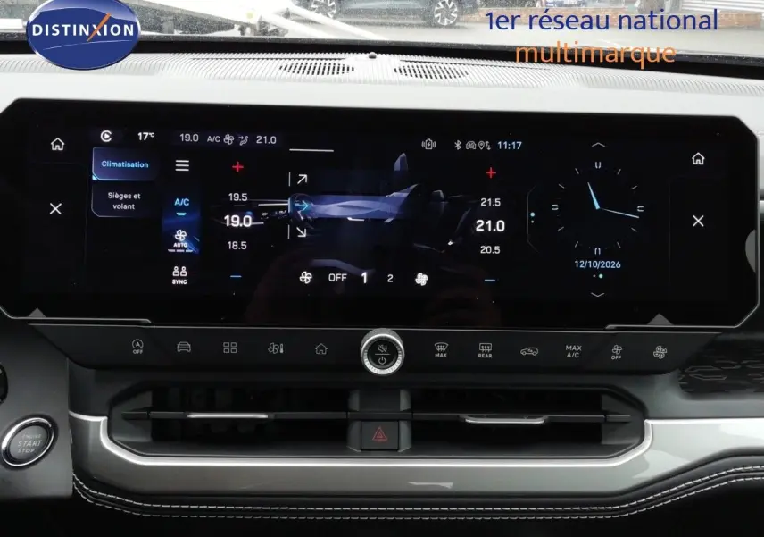 Vue rapprochée de l’écran tactile central du Jeep Compass 2026 noir Vulcano, affichant la climatisation et l’horloge digitale.