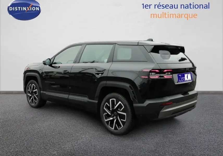 Jeep Compass noir Vulcano métal vu en 3/4 arrière droit, avec jantes alliage distinctives et feux arrière LED allumés.