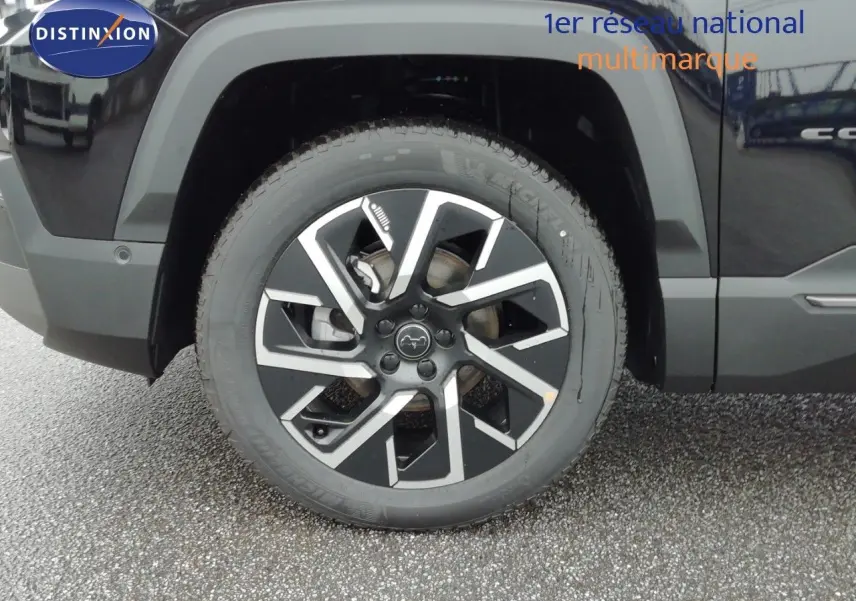 Gros plan sur la roue avant gauche du Jeep Compass noir Vulcano Métal avec jante alliage au design moderne.