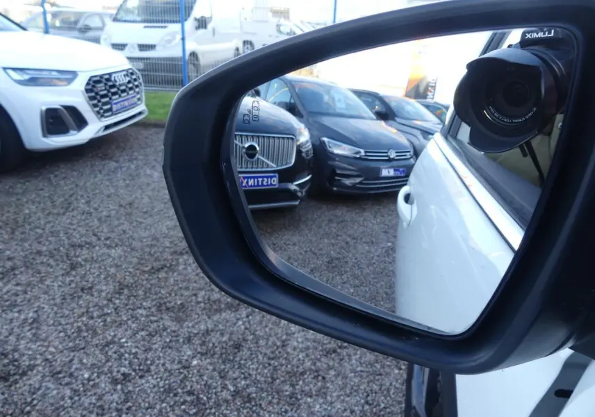 Rétroviseur côté droit d'un Peugeot 3008 blanc nacré, avec reflet de plusieurs voitures en arrière-plan.
