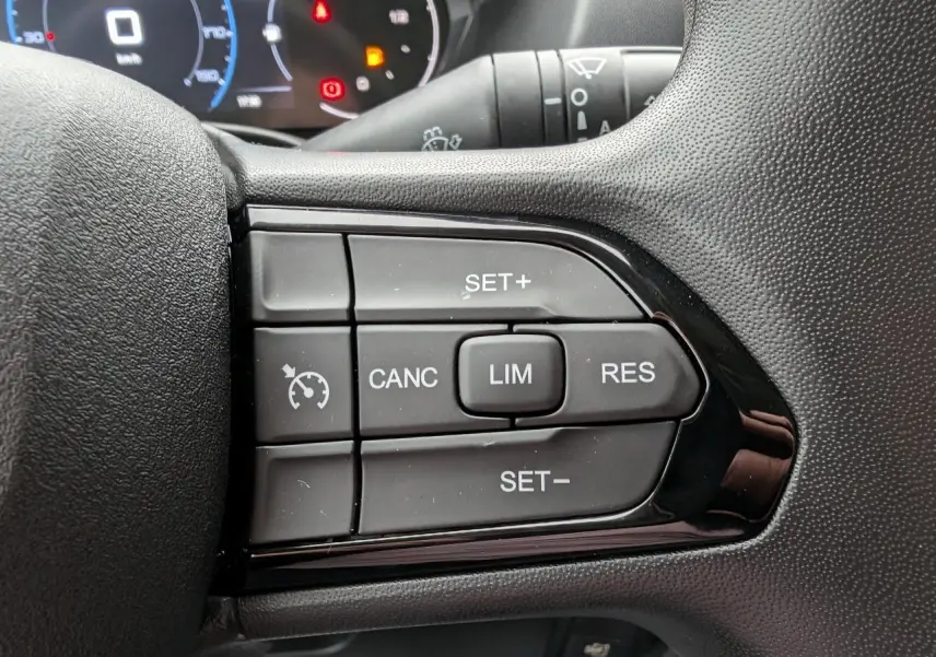 Gros plan sur les commandes du régulateur de vitesse au volant du Citroën Jumper 2025, finition noire.