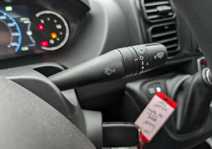 Gros plan sur la commande d'essuie-glace du tableau de bord du Citroën Jumper blanc 2025, intérieur noir.