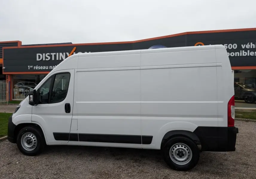Vue de profil côté gauche d'un utilitaire Citroën Jumper blanc avec porte latérale coulissante et roues acier.