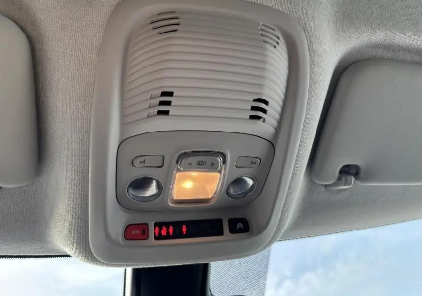 Gros plan sur les commandes audio au volant en cuir noir de la Citroën C3 Aircross 2021, tableau de bord en arrière-plan.