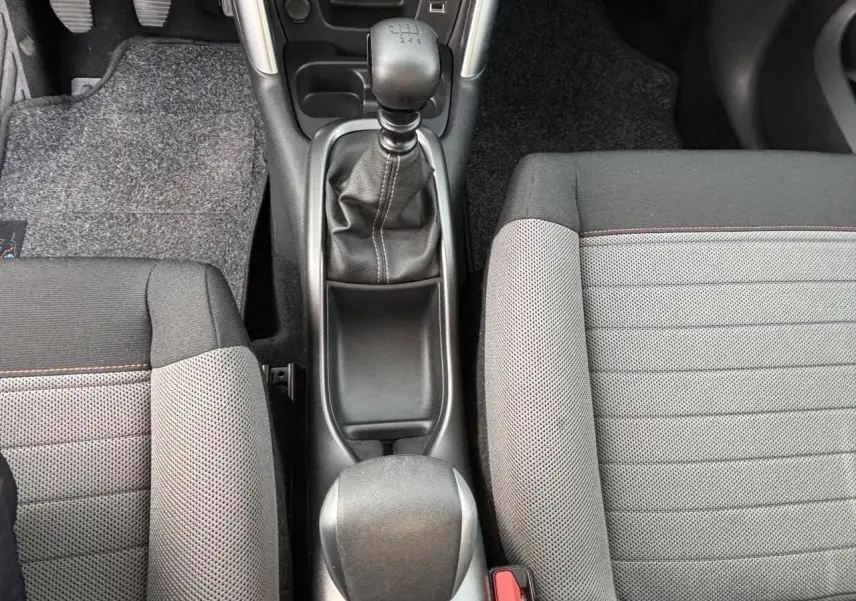 Intérieur avant droit de la Citroën C3 Aircross 2021 avec sièges tissu gris et bande rouge, volant et tableau de bord visibles.