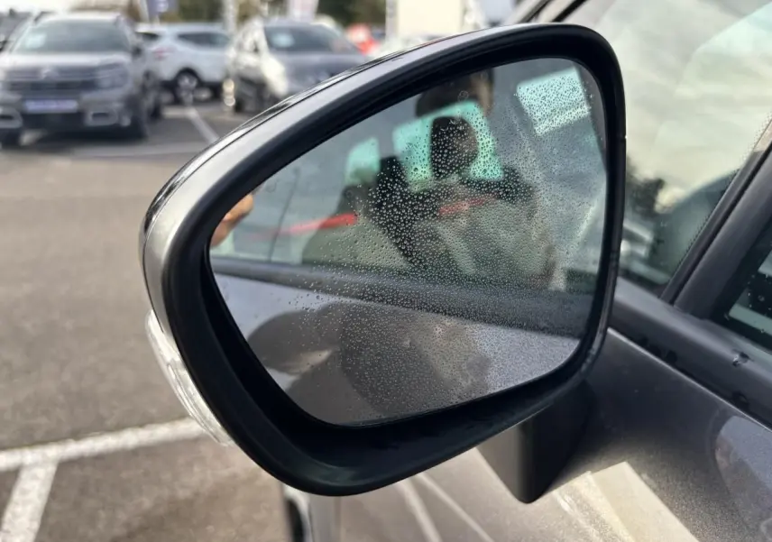 Gros plan sur les commandes des vitres électriques et réglages des rétroviseurs côté conducteur d'une Citroën C3 Aircross gris platinium.