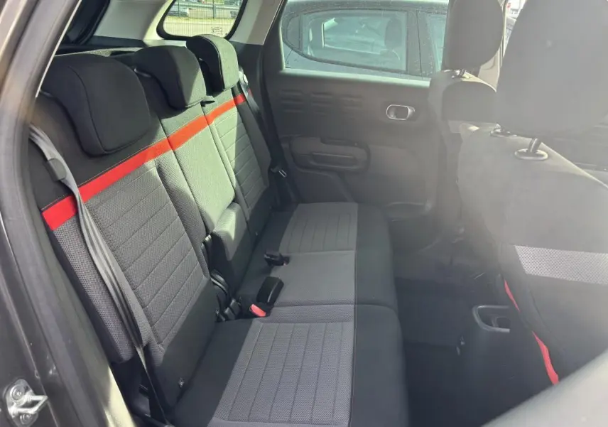 Gros plan sur la roue arrière droite d'une Citroën C3 Aircross gris platinium avec jante alliage 17'' damantée.