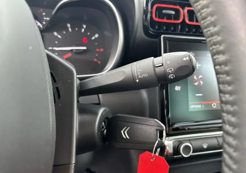 Gros plan sur la commande d’essuie-glace et clé de contact dans l’habitacle noir du Citroën C3 Aircross 2021.