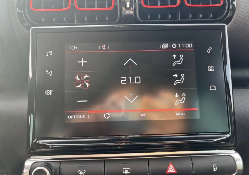 Écran tactile central de la Citroën C3 Aircross 2021 affichant la climatisation à 21°C avec cadre noir brillant et aérateurs rouges.