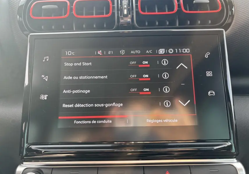 Vue rapprochée de l'écran tactile central du tableau de bord du Citroën C3 Aircross avec contours d'aération rouges.
