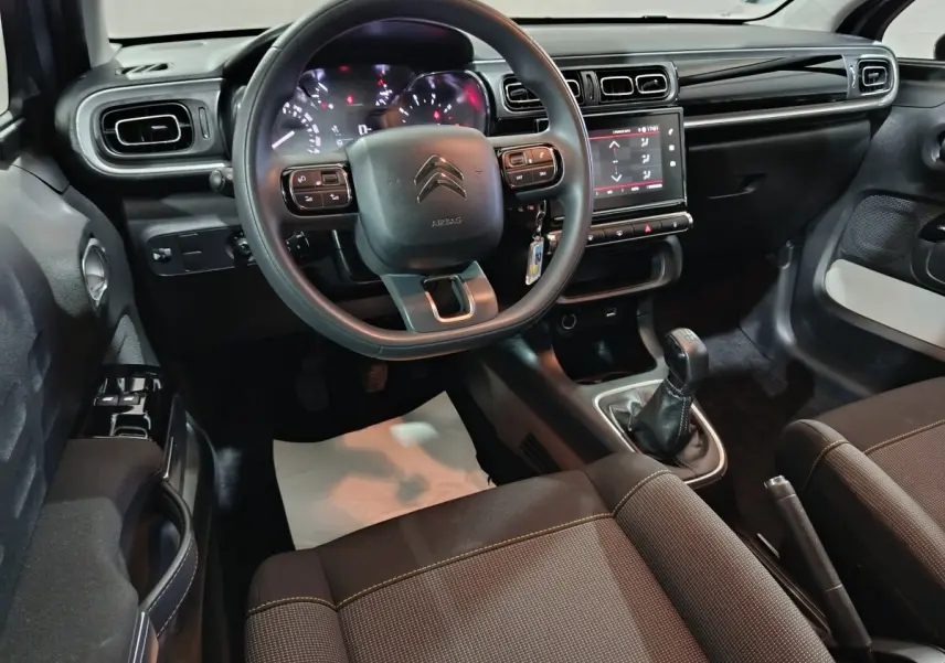 Intérieur de la Citroën C3 PureTech 83 BVM 2024, vue avant centrée sur le volant et la console tactile noire.