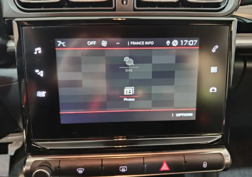 Écran tactile central de la Citroën C3 PureTech 83 BVM MAX 2024 affichant menu SMS et photos, vue rapprochée intérieure.