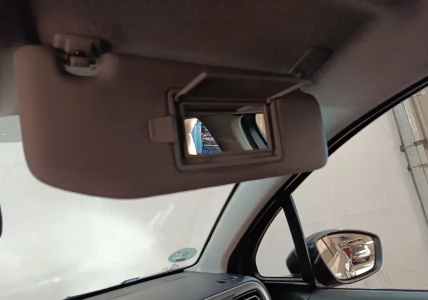 Miroir de courtoisie ouvert sur pare-soleil côté conducteur dans l’habitacle d’une Citroën C3 gris foncé 2024.