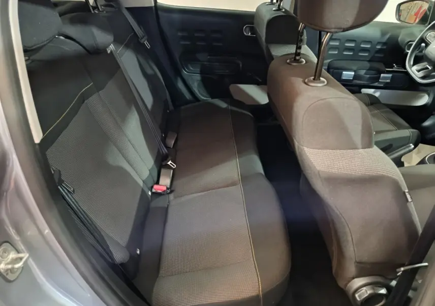 Vue intérieure côté gauche sur la banquette arrière noire avec surpiqûres jaunes d'une Citroën C3 gris foncé 2024.