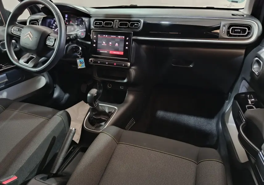 Intérieur avant de la Citroën C3 gris foncé, vue côté conducteur, tableau de bord avec écran tactile central et volant multifonctions.