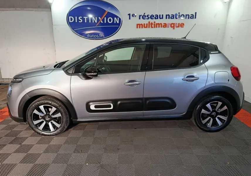 Profil côté gauche d'une Citroën C3 gris foncé 2024 avec protections latérales noires et toit noir contrasté.