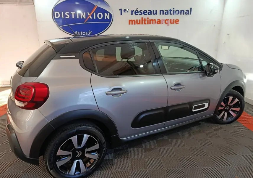 Citroën C3 gris foncé vue de profil côté droit, avec protections latérales noires et jantes stylisées.