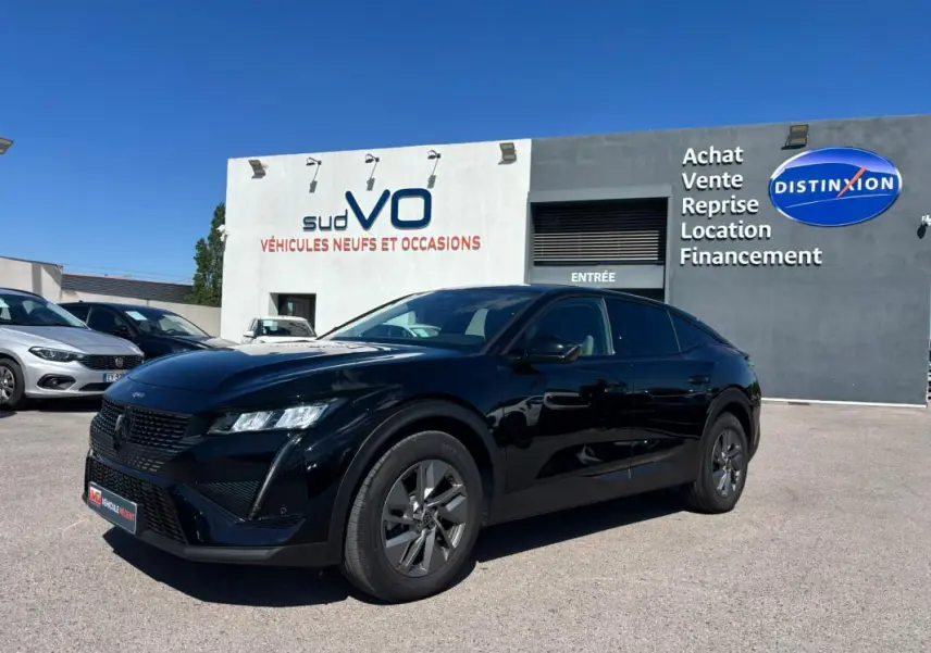Peugeot 408 Hybrid noir vue 3/4 avant droit, jantes alliage 19 pouces, stationnée devant un concessionnaire.