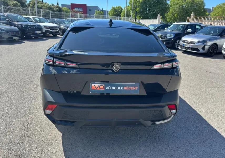 Vue arrière d’une Peugeot 408 noire 2025 avec feux LED distinctifs et jantes alliage 19 pouces, en extérieur.