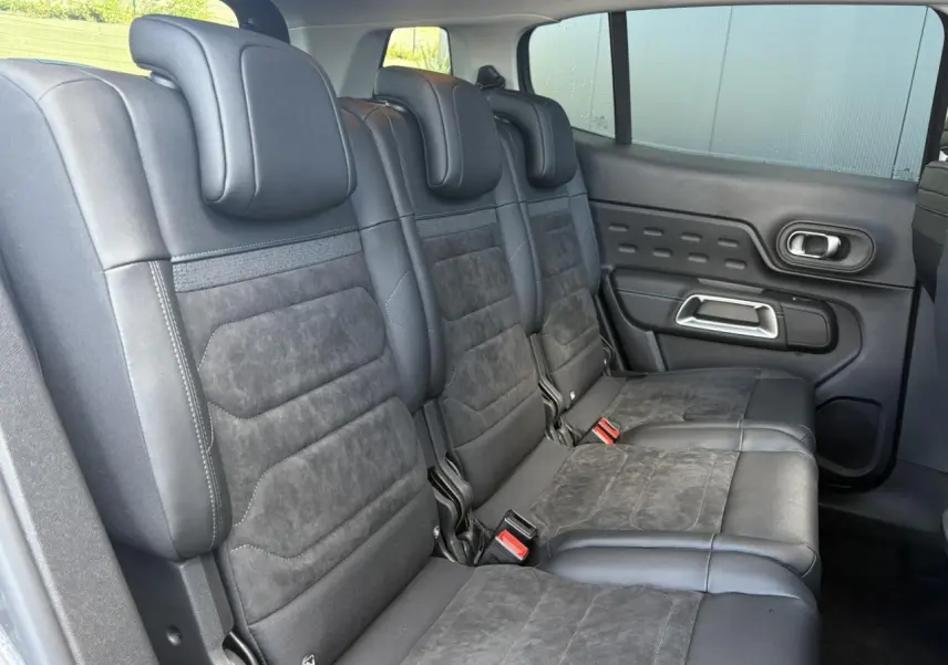 Vue latérale intérieure des sièges arrière en Alcantara noir du Citroën C5 Aircross 2025 avec appuie-têtes et ceintures visibles.